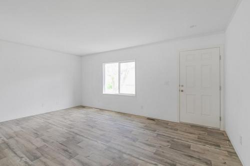 Empty room with hardwood floors and white walls.