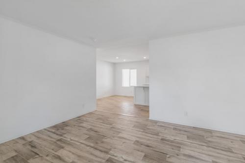 An empty room with white walls and wood floors.